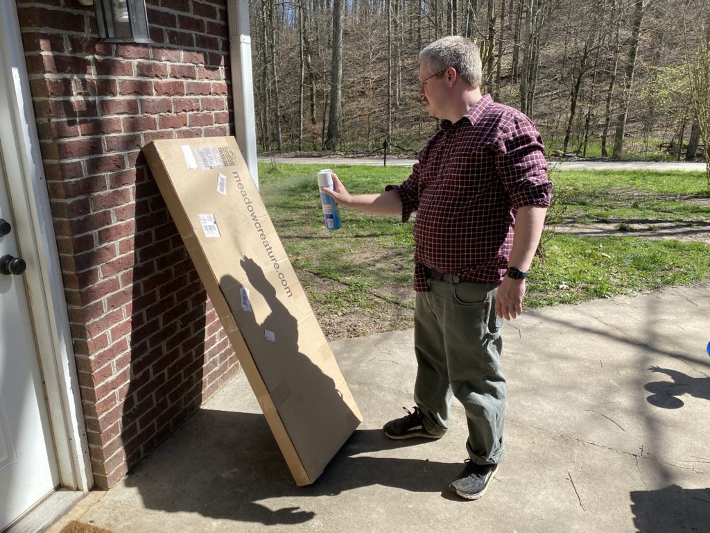 The author disinfecting a package with Lysol.